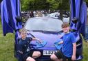 Isaac Handbury, ten and Zach Curtis, eleven help polish a 750s Spider, McLaren in Aurora Blue