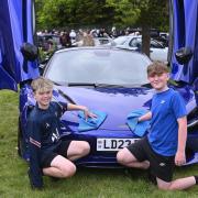Isaac Handbury, ten and Zach Curtis, eleven help polish a 750s Spider, McLaren in Aurora Blue