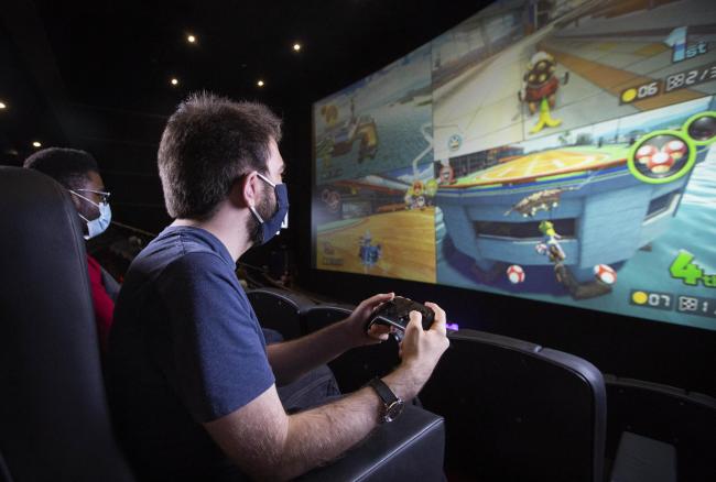 Gaming influencer Rhys Farrant, known online as Gameasertm, plays Xbox on the big screen at Cineworld Leicester Square in London, as the cinema announces private screen hire for gaming fans at 100 different venues across the UK. Credit: PA