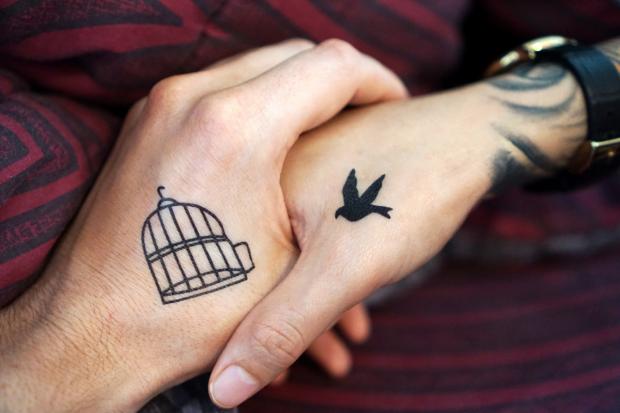 Stroud News and Journal: Two people with tattoos holding hands (Canva)