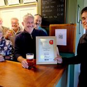 Tony Hill (right, chair of Stroud CAMRA) presents the certificate to Rob and Ali Brady from Chalford Sports & Social Club with Stroud CAMRA members