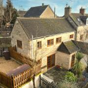 This property boasts five bedrooms and period features including exposed Cotswold stone walls and wooden beams
