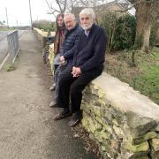 Chalford Hill residents (from left) Josie Felce, Steve Swan and David Huband sitting on the restored boundary wall. FREE TO USE FOR ALL PARTNERS. CREDIT: Carmelo Garcia