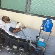Amo Singh in hospital after he was attacked and, inset, a CCTV image of the moment a car ploughed into him
